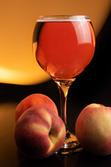 Drink, glass of sparkling wine with peaches around and colored light in the background, light painting style photo, selective focus.