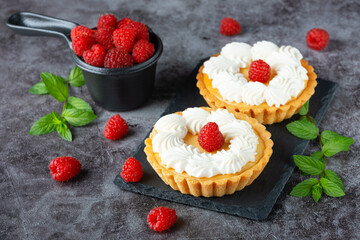 Creamy cheesecake cake with raspberries on a gray table