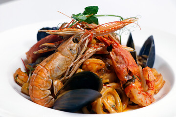 seafood linguine pasta with langostino, octopus, squid rings, shrimps, mussels, scampi and clams in white wine marinara sauce