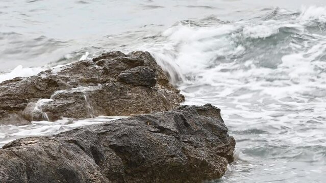 Wavy water crashing huge rocks