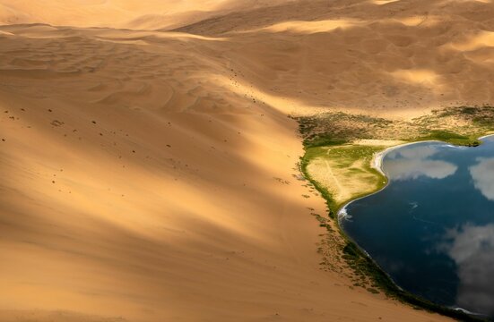 Salt lake in the Badain Jaran desert, the lake reflects the sky in the sunlight