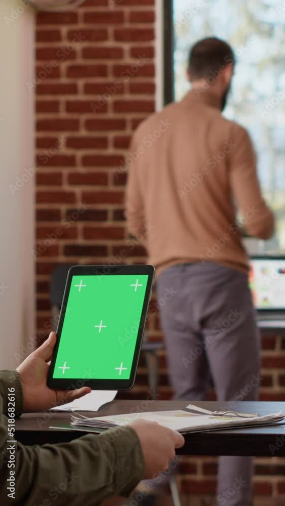 Aufkleber vertical video: businessman looking at digital tablet with greenscreen display in company office. us