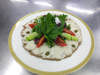 vitello tonnato - italian dish of veal slices with mayonnaise, tuna and capers sauce on a white background. tasty and healthy food