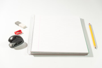 school equipment and blank notebook on a table