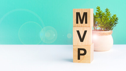 mvp - acronym from wooden blocks with letters Minimum Viable Product, concept. green background....