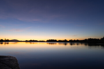 sunset over the river colorful skies amazing calm waters cotton candy sky dusk trees and mountains...