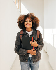 Happy student walking in corridor. Girl in casuals in college.