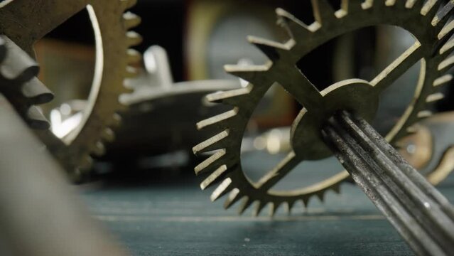 Metal dirty, dusty internal parts of an old clock. Clockwork, gears, cogwheels, gearwheel and spring on blurred background. Disassembled clock mechanism of an old watch. Clock workshop. Macro shot.