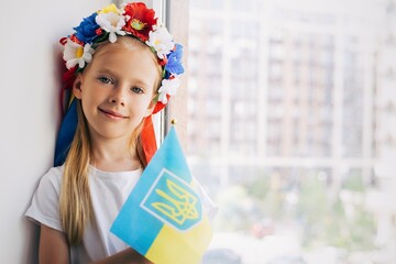 Girl with a flag of Ukraine. Child. Ukrainian child. War. Blue. Yellow. Pray for Ukraine. Ukrainian wreath on the head - 518685857