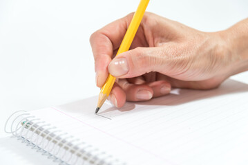 hand writing a sheet of paper with a pencil