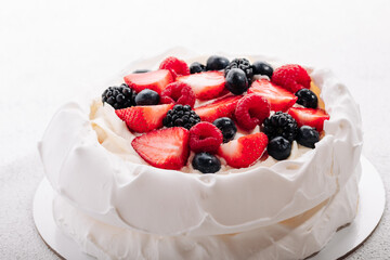 Pavlova meringue cake with fresh berries on white background