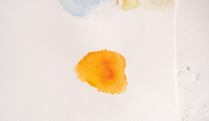 detalle de mancha de acuarela sobre papel blanco con textura, color naranja