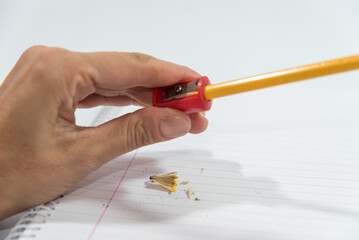 hand sharpening a pencil with a sharpener