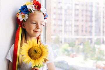 portrait of a little girl with flowers
Ukrainian wreath on the head
Ukraine little girl waiting for her father from the war. War.  - 518686231