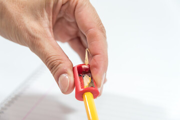 hand sharpening a pencil with a sharpener