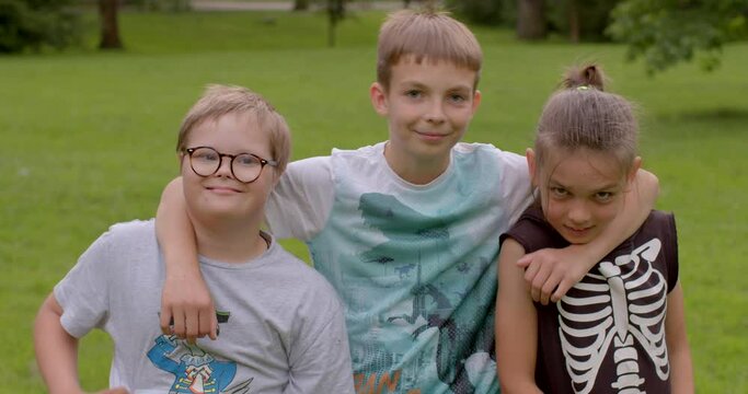 Portrait of children pose looking at the camera, hugging. Satisfaction of raising a child with Down syndrome, Inclusion is involvement and empowerment, promotes and nurtures a sense of belonging.