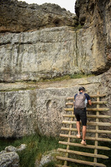Joven subiendo una escalera de madera apoyada en una montaña rocosa - Piedras del Chivo Negro, Cundinamarca, Colombia