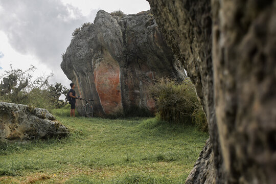 Joven explorando grandes y antiguas rocas con pintura rupestre, antiguo territorio muisca - Piedras del chivo negro, Cundinamarca, Colombia