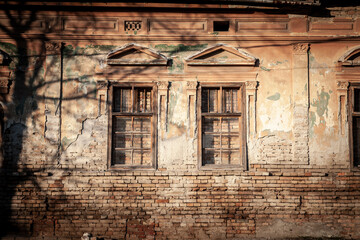 Condemned bricked up & boarded windows on an old Facade of vintage damaged house residential building in an area ready for destruction, reconstruction & renovation.....