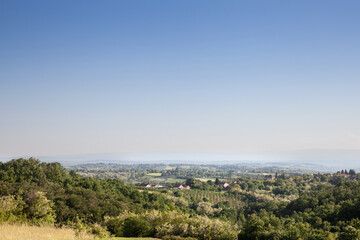Fototapeta premium typical European countryside landscape, with farms, agricultural fields, trees, in a valley , in Sopot Municipality, Central Serbia, in Kosmaj mountain, in a traditional European rural environment