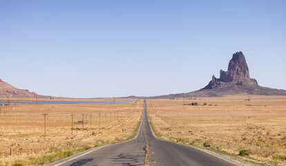 Scenic Road in the Dry Desert with Red Rocky Mountains in Background. Oljato-Monument Valley, Arizona, United States.