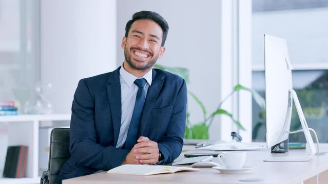 Business man typing and browsing on a computer while working in an office. Portrait of one ambitious and confident young entrepreneur smiling while doing research and planning online in a company