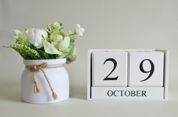 October 29, Cover natural background, white wooden Calendar cube with a pot flower on white...
