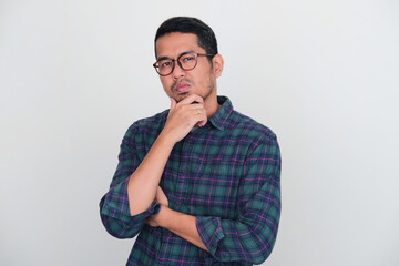 Adult Asian man touching his chin with arrogant expression