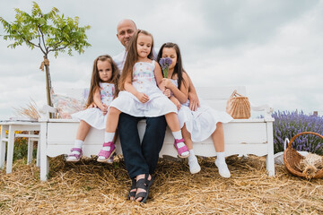 Family with three children sitting on the bench outdoors in a park talking chatting.Happy cheerful family on vacation. Mom, and three children are playing, hugging.