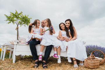 Fototapeta premium Happy kids dad and mom are kiss.The family spends leisure time in the fresh air. Native sisters are having fun. 