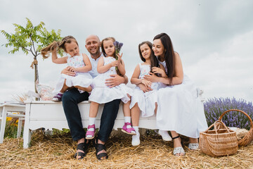 Happy dad and mom hug their adorable kids.