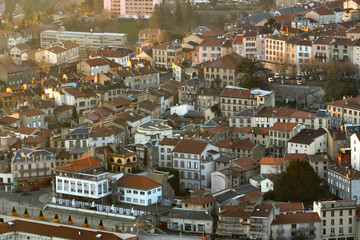 Aerial view of dense historic center of Thiers town in Puy-de-Dome department, Auvergne-Rhone-Alpes region in France. Rooftops of old buildings and narrow streets at sunset