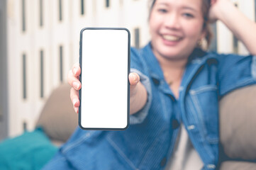 Close up relax women showing a smartphone with an empty white screen lazy on the sofa at home.