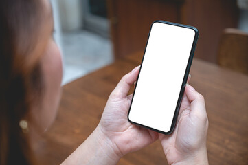 Close up women using a smartphone with an empty white screen at home.