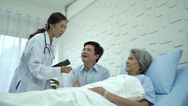 Man taking care his mother while recovery in the hospital and doctor comes to talk to patient.