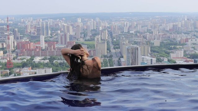 Attractive woman in swimming pool on roof