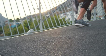Feet of fitness group taking off and starting a race while on a urban city street. Sportive athlete friends wearing comfortable running shoes for sports challenge while exercising together outdoors
