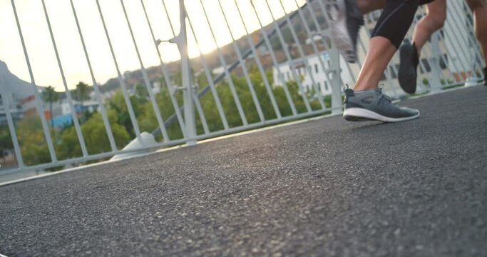 Feet of fitness group taking off and starting a race while on a urban city street. Sportive athlete friends wearing comfortable running shoes for sports challenge while exercising together outdoors