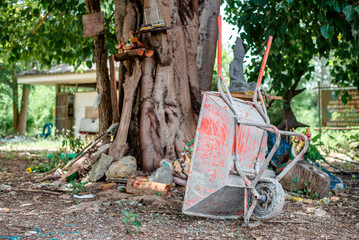 Orange wheelbarrow to put cement that has been used for a long time, causing cement to be stuck all over the car.