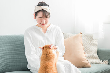 猫におやつをあげる日本人女性（餌）
