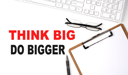 THINK BIG DO BIGGER Concept. Calculator,pen and glasses on the white background