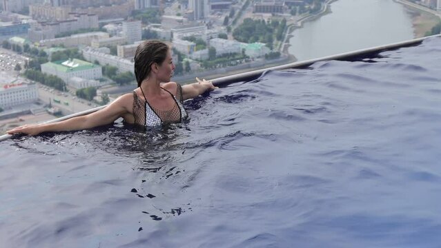 Attractive woman in swimming pool on roof