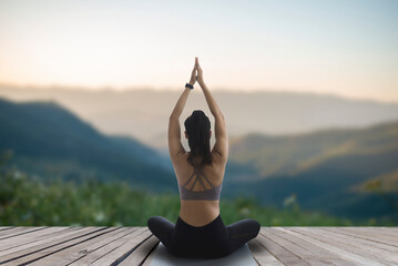 Woman practicing yoga and meditating outdoor exercise. Beautiful girl practice yoga pose and body balance vital zen meditation for workout nature mountain background in morning sunrise.