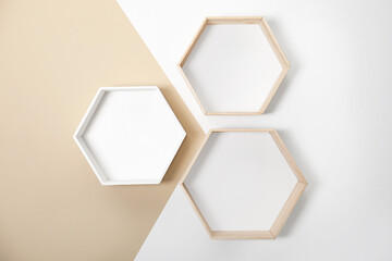 Empty honeycomb shaped shelves on color wall