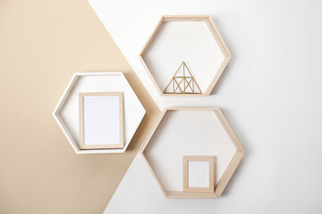 Honeycomb shaped shelves with decorative elements on color wall
