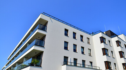 Obraz premium Exterior of new apartment buildings on a blue cloudy sky background. No people. Real estate business concept.