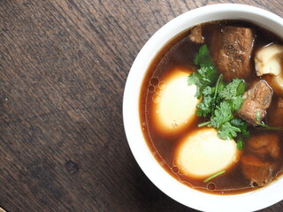 top view bowl of braised egg and pork stew with five spice on wooden table