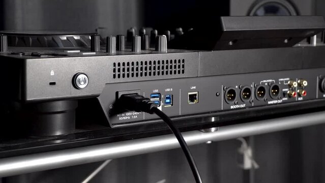 Connecting power and XLR cables to DJ mixer (3/4 view)