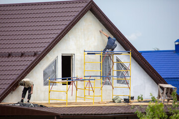Workers are plastering the walls of the house.