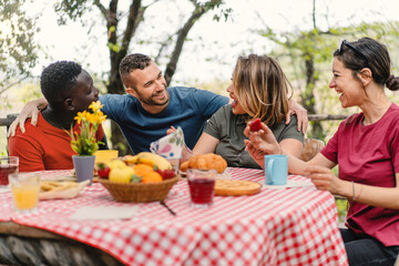 Group of cheerful multiethnic friends meets at brunch table - People and food lifestyle concept